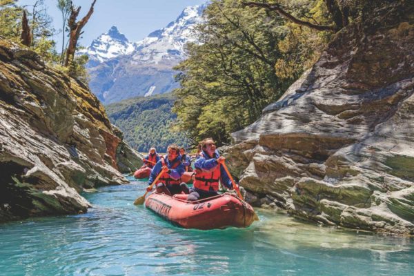 guests on the dart river funyak tour kayaking down blue water in glenorchy new zealand